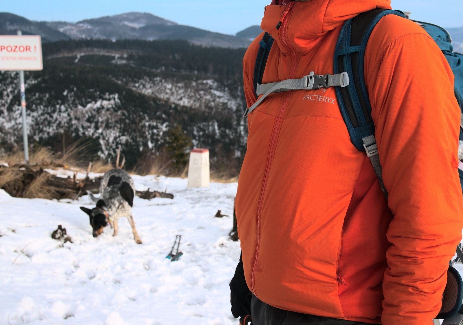 An orange Arc’teryx Atom LT jacket worn outdoors in snow